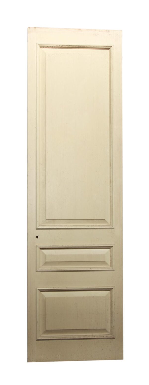 Off-white wood door with three recessed panels and a single large upper panel.