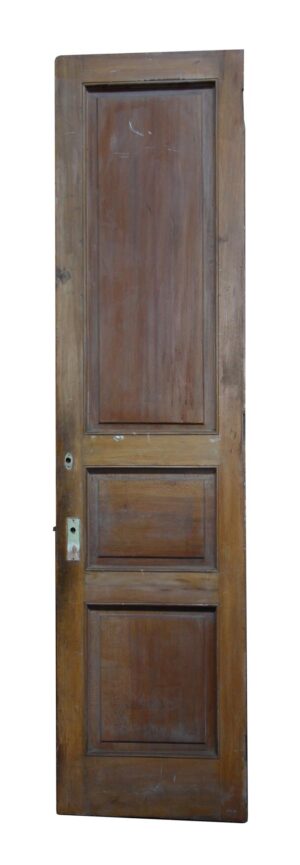 Three-panel narrow wood door with a dark wood tone and visible lock hardware openings.