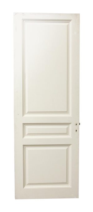 White wooden door with three raised panels and a lock hole on the right side.
