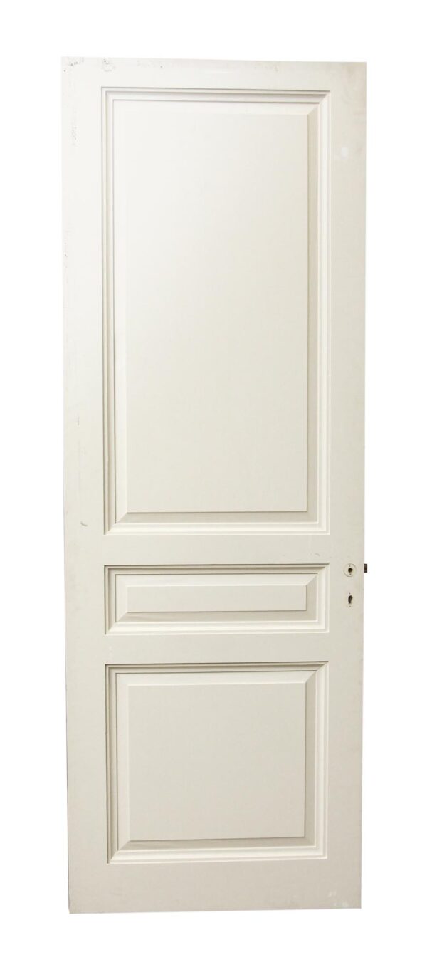 White wooden door with three raised panels and a lock hole on the right side.