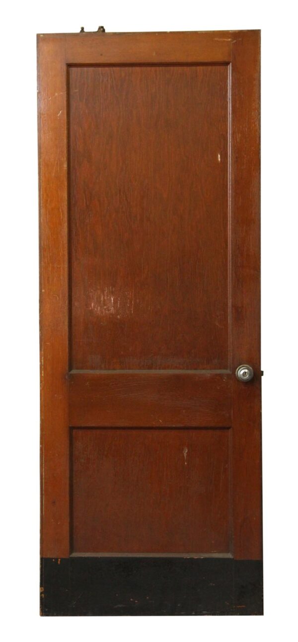 Wood door with two panels, a kick plate at the bottom, a Norton door closer at the top, and a nickel-finished knob on the right side.