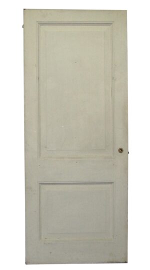White wood passage door with two raised panels and a round latch hole visible on the right side.