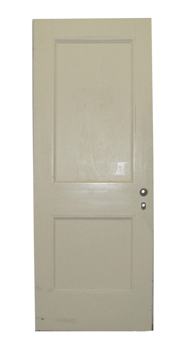 Vintage white wooden door with two recessed panels and a pair of visible hardware holes on the right side.