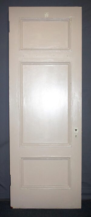 White wooden passage door with three recessed panels, shown front-facing with the hardware hole visible on the right side.