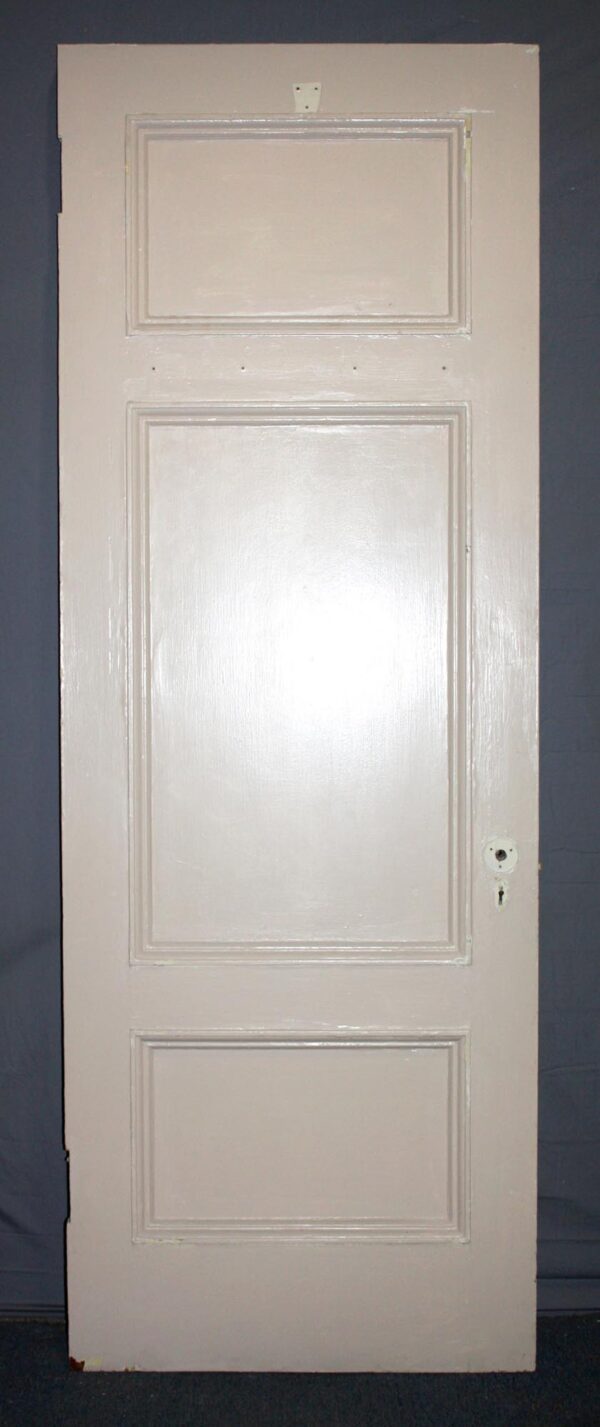 White wooden passage door with three recessed panels, shown front-facing with the hardware hole visible on the right side.