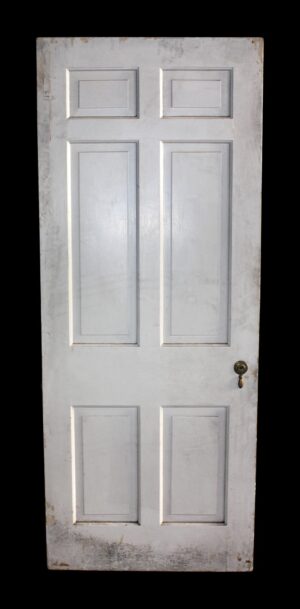 Six-panel white wood passage door with original hardware visible on the right side.
