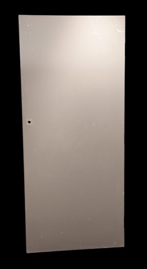 Plain tan wooden passage door with a flat surface and a single hole for hardware.