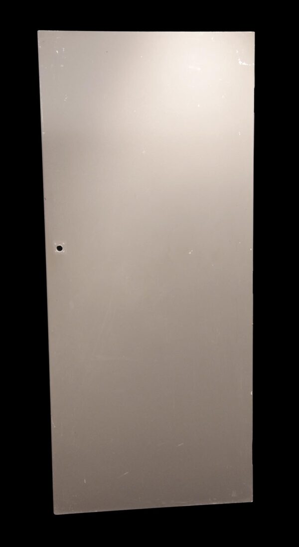 Plain tan wooden passage door with a flat surface and a single hole for hardware.