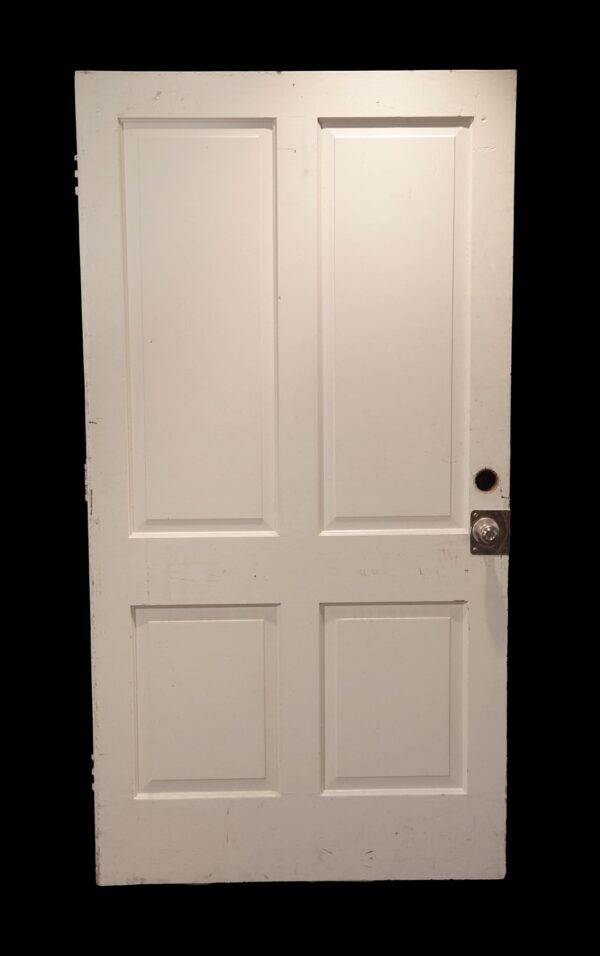 Vintage white wooden door with four panels and a round knob hole on the right side.