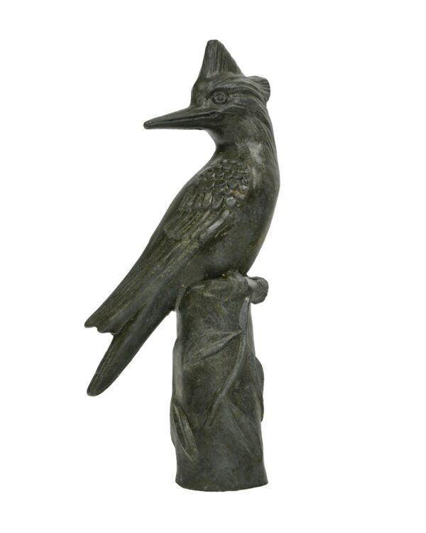 Black bronze woodpecker statue perched on a leafy log, shown in side profile with visible age wear.