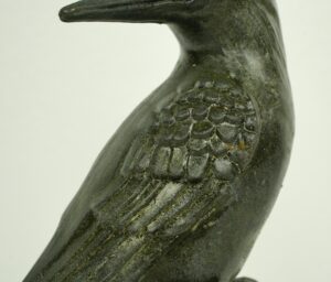 Black bronze woodpecker statue shown in close-up, with the carved wing and long beak visible.