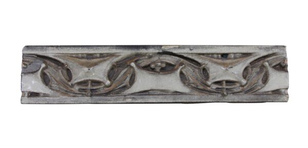 Gothic terra cotta facade trim stone with a crackled gray and tan surface and carved repeating arch motifs.