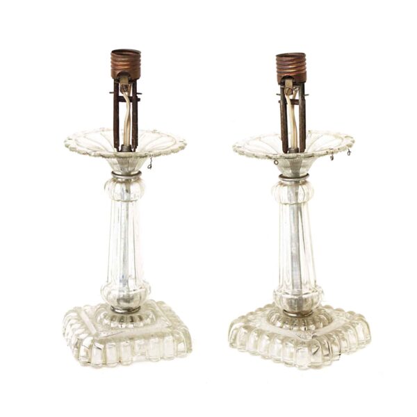 Pair of clear glass table lamps with scalloped bases and exposed sockets, shown side by side as a pair.