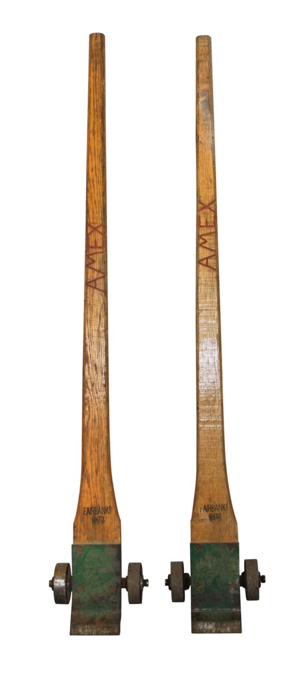 Pair of antique crate levers with medium wood handles and metal bases, shown upright side by side.