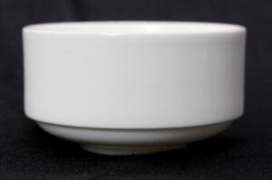 White bone china soup bowl shown in a side view, with the rounded rim and foot visible.