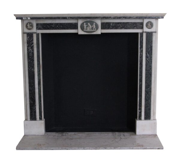 Front view of a marble mantel with a large rectangular firebox opening, fluted side columns, and small figural medallions across the top frieze.
