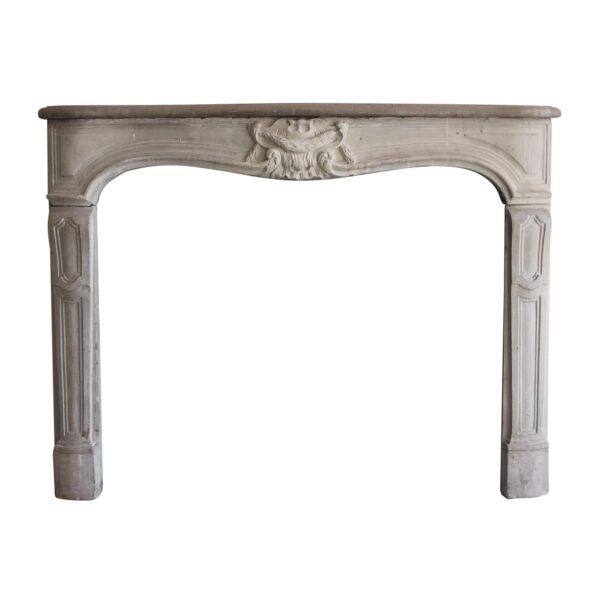 Louis XV limestone mantel with carved decorative center detail and a curved opening, shown in a front view.