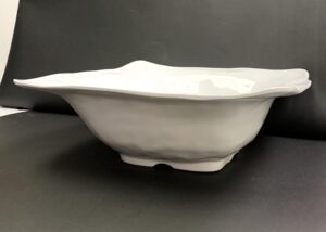 White melamine serving bowl with a ruffled rim shown in side profile.