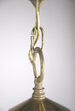 Close-up of a brass lantern light chain and top mount with a partial view of the brass body below.