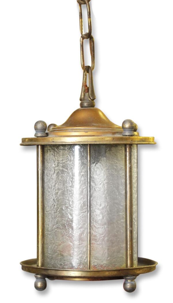 Traditional curved glass foyer ceiling lantern with antique brass finish, showing the hanging chain and textured glass panels.
