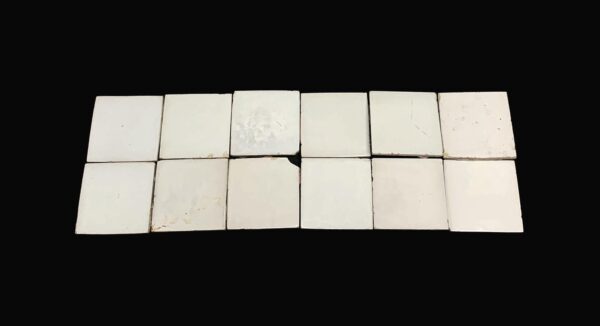 Set of 12 white square ceramic wall tiles with a shiny surface, shown with age-related chips and scrapes.