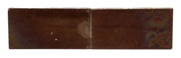 Pair of brown ceramic tiles shown side by side, with visible age-related imperfections, minor chips, and surface scrapes.