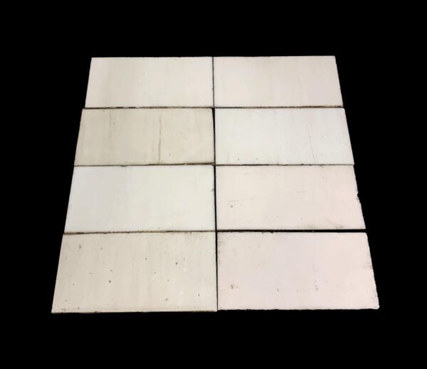 Square foot of thin white glass tiles arranged in a grid, shown with a plain surface and visible age marks and scrapes.