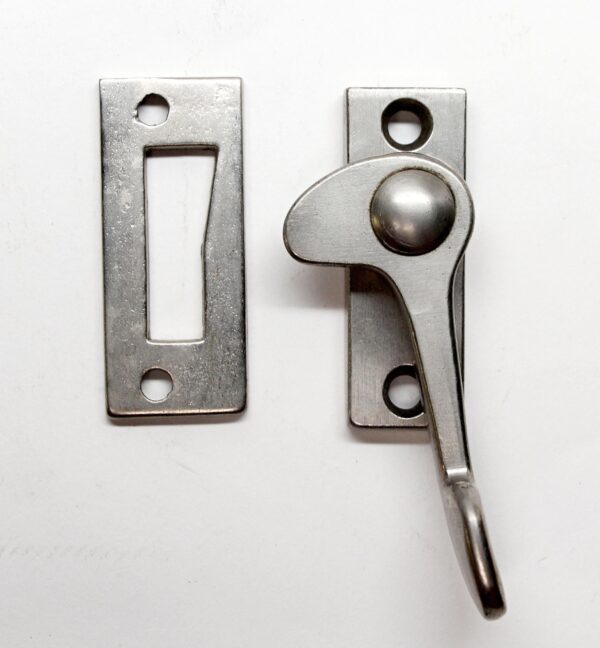 Vintage nickel plated window latch shown with two metal plates, one flat and one with the lever raised.