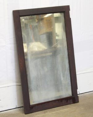 Distressed beveled cabinet door mirror with a dark wood tone frame shown at a slight angle.