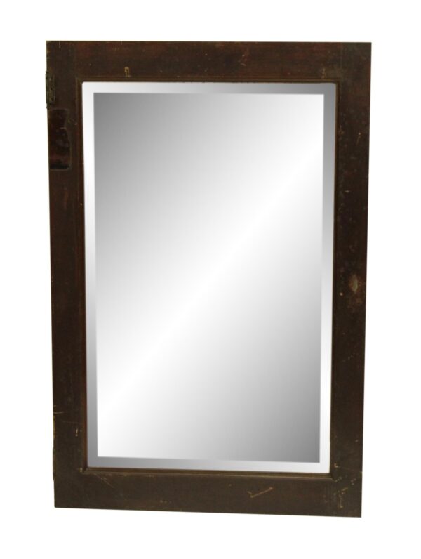 Wood-framed cabinet mirror door with beveled glass and visible wear along the edges.