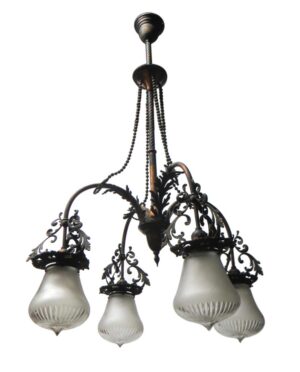 Victorian four-arm chandelier with ornate scrollwork, four frosted glass shades, and a hanging cord from the ceiling mount.