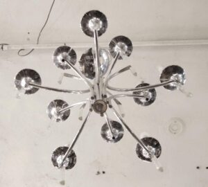 Mid-century chrome chandelier with ten curved arms and crystal accents, shown from below.