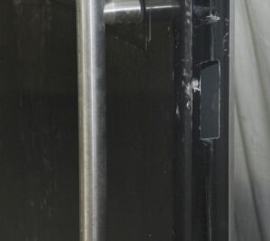 Black metal commercial door with one glass panel and a full-length pull bar shown in close-up.