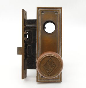Antique bronze entry door knob set with a rectangular back plate and circular knob showing the Lefcourt Newark emblem.