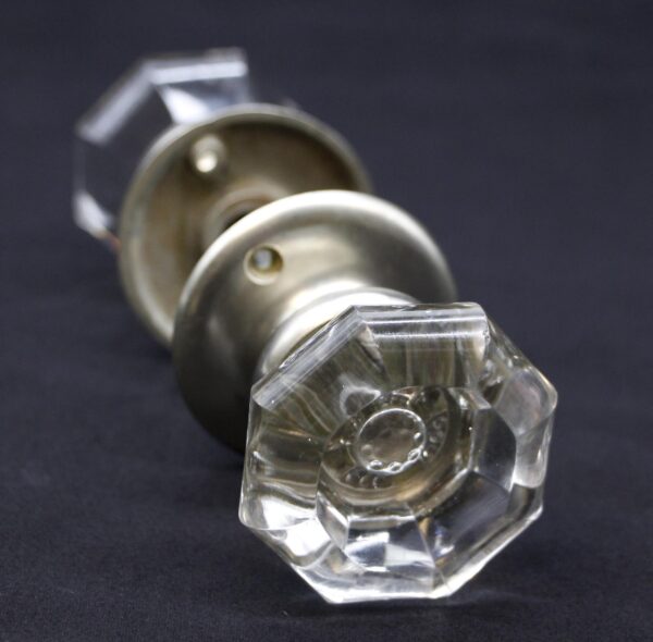 Clear glass octagon door knob with brushed nickel shank and rosette, shown in close-up with the mounting hardware visible behind it.