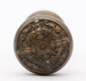 Antique bronze entry door knob with ornate Flemish floral relief and rounded profile.