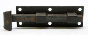 Vintage iron door bolt with a black surface and rectangular mounting plate, shown with the sliding bolt extended and no catch included.