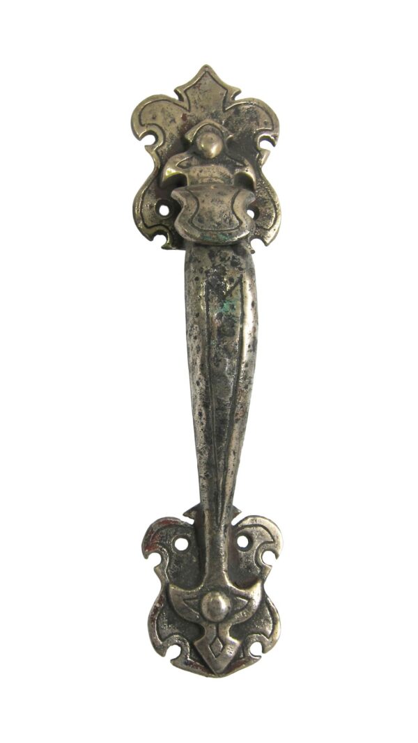 Antique cast iron door handle with a thumb latch and hammered surface, shown front on.