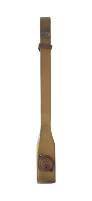 Antique brass commercial door pull with a long narrow backplate and a round lock near the bottom.