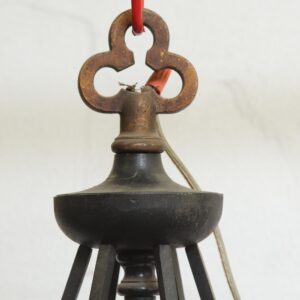 Close-up of a Gothic pendant light with a black lower section and copper-colored top, shown without the bottom glass and with a wire visible.