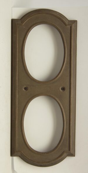 Bronze elevator indicator plate with two oval openings and mounting holes, shown without the glass buttons.