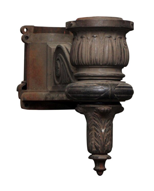 Pair of black cast iron lamp post sconces with an ornate fluted base and mounting bracket, shown in a close-up product view.
