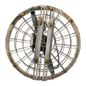 Vintage metal fan with a circular wire cage and worn front grille, shown from the front.
