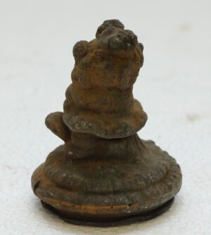 Cast iron teddy bear mold shown upright with a heavily worn, rusted surface and rounded base.