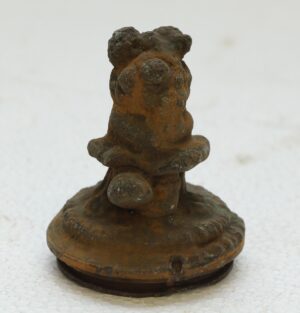 Cast iron decorative teddy bear mold shown upright with a rounded base and textured, worn surface.