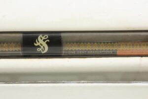 Close-up of the scale’s front window with numbered weight graduations and the Sanitary Scale logo visible on the white metal body.
