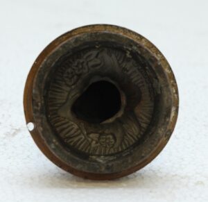 Cast iron mold shown from above with a teddy bear design inside the circular cavity.