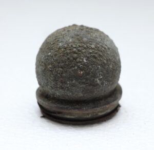 Small round cast iron mold with a domed, textured top and flat base.