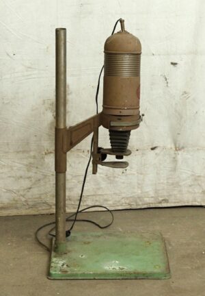 Vintage brown and green metal photo enlarger on a stand, shown with its column, lens bellows, and base, with visible wear.