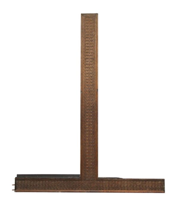 Dark wood tone T-shaped wood molding with a swirled carved pattern, shown in a long vertical and horizontal profile.